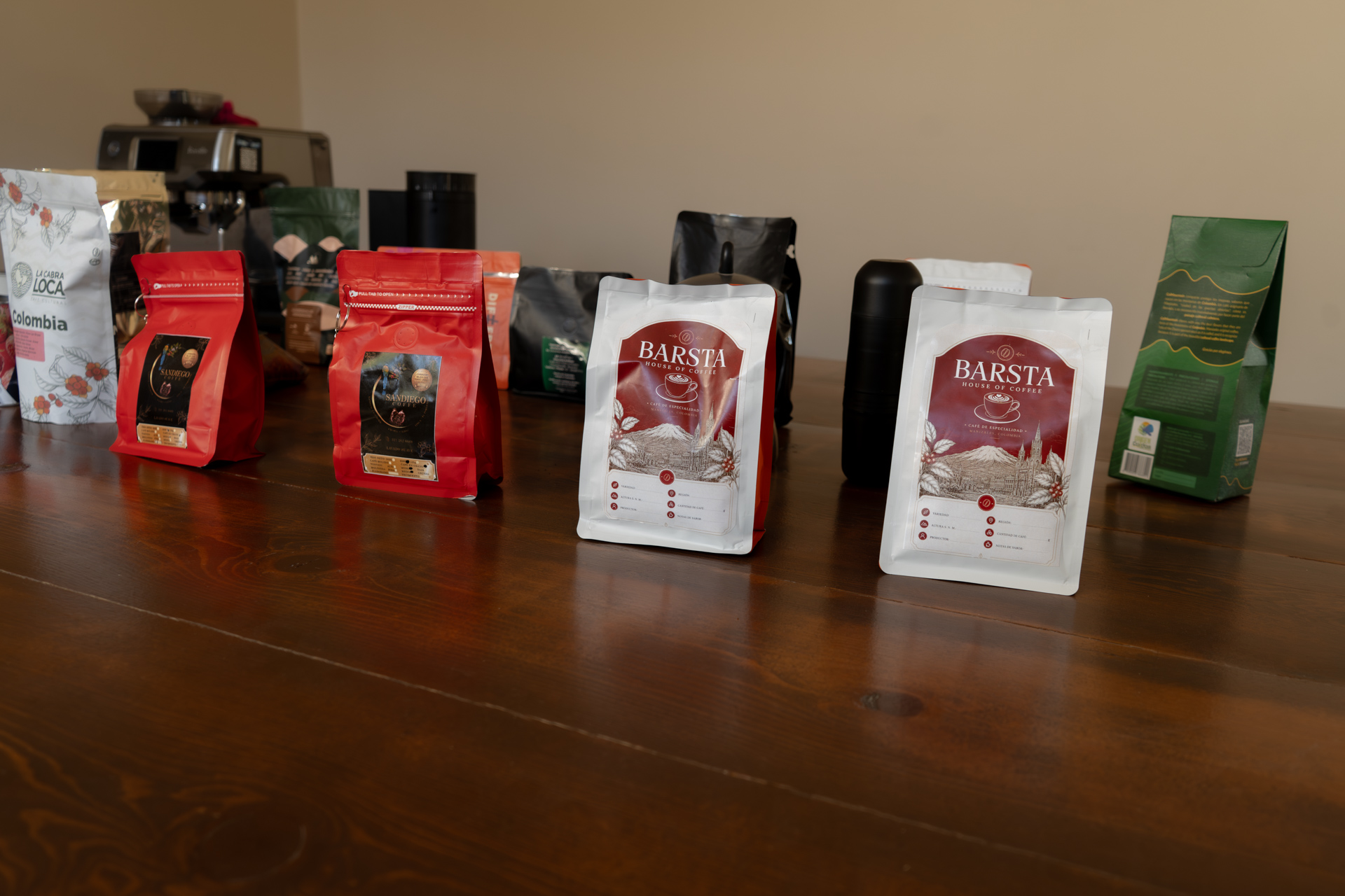 Bolsas de café alineadas sobre mesa de madera